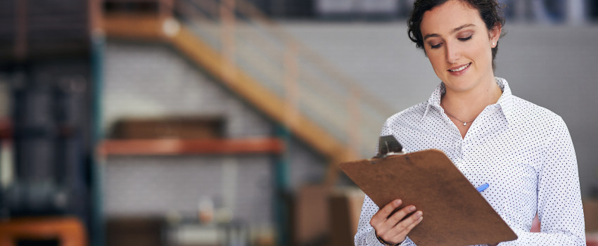 Woman in dress shirt holding a clipboard