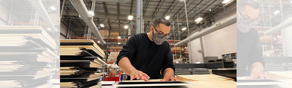 Man wearing face mask assembling archival binders in a warehouse