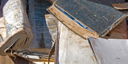 Pile of books with warped pages and water damage